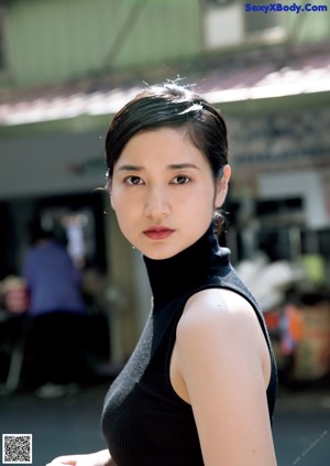 A woman in a black top and a purple skirt.