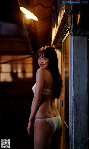 A woman laying on top of a bamboo mat smiling.