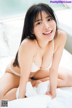 A woman laying on a blue couch under a white blanket.