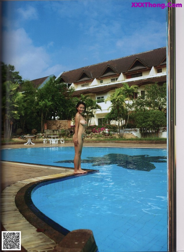 A woman standing on the edge of a swimming pool.