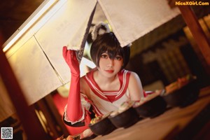 A woman in a red and white outfit sitting on the floor.