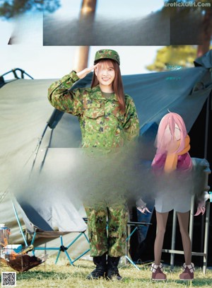 A woman in a military uniform holding a shovel.