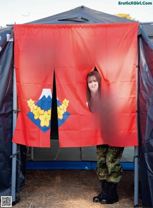 A woman in a military uniform holding a shovel.