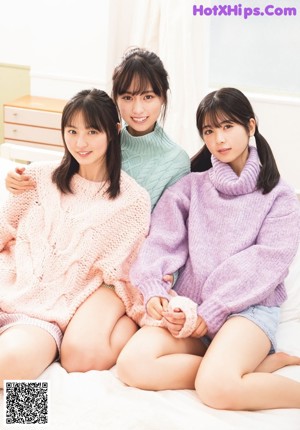 A group of young women eating food in a kitchen.