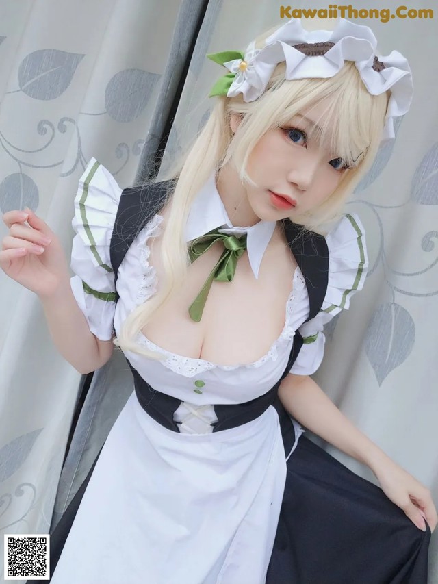 A woman in a maid outfit posing for a picture.