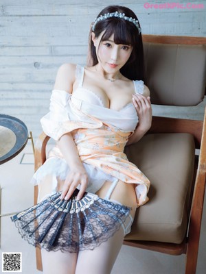 A woman in a white lingerie sitting on a chair.