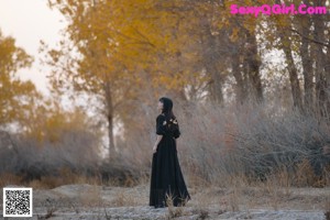 A woman standing on top of a sand dune.