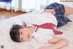 A woman laying on a bed wearing a school uniform.