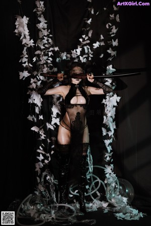 A woman in a black lingerie and goggles posing for a picture.