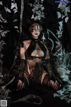 A woman in a black lingerie and goggles posing for a picture.