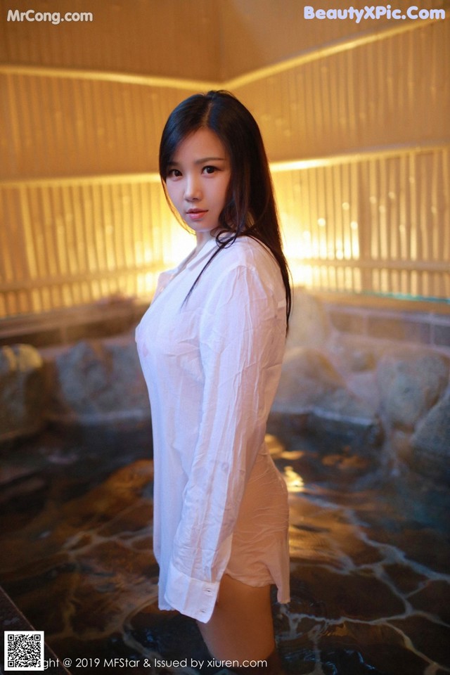 A woman in a white shirt standing in a hot tub.