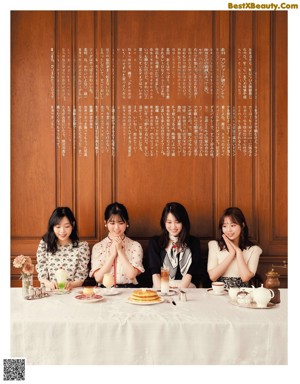 A group of young women sitting at a table eating food.