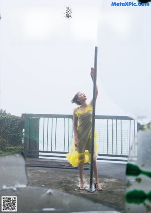 A woman in a pink and orange dress standing in the middle of a street.
