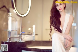 A woman in a white dress posing for a picture.