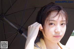 A woman in a school uniform leaning against a wall.