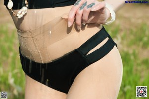 A woman in a black bikini standing on a beach.