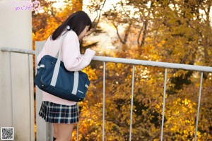 A woman in a school uniform is posing for a picture.