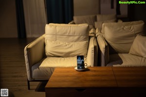 A woman laying on a couch holding a cell phone.