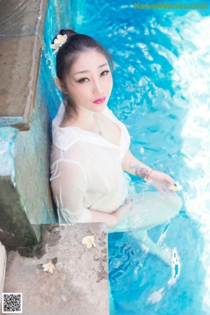 A woman sitting in a bathtub covered in foam.