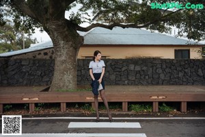 A woman standing next to a car on the side of the road.