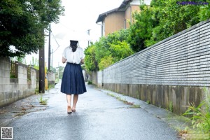 A woman in shorts and a tank top is looking at her cell phone.