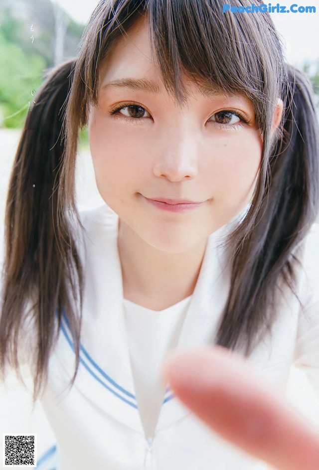 A young woman with long black hair and a white shirt.