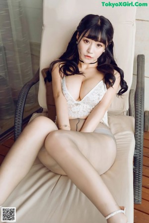 A woman in a white corset posing on a balcony.