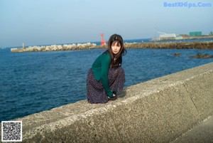 A woman standing in front of a large boat.