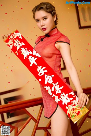 A woman in a red dress standing in front of a door.