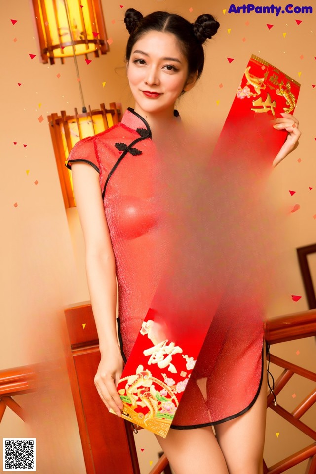 A woman in a red cheongsam holding a red envelope.