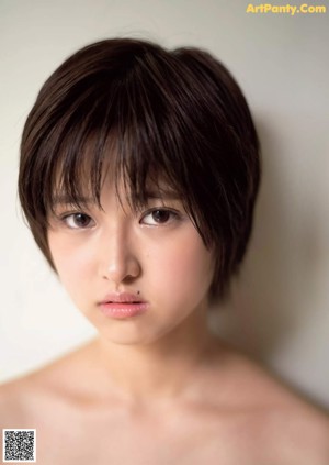 A naked asian woman sitting on a tatami mat.