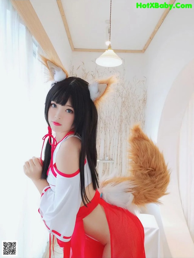 A woman in a red and white outfit with a fox tail.