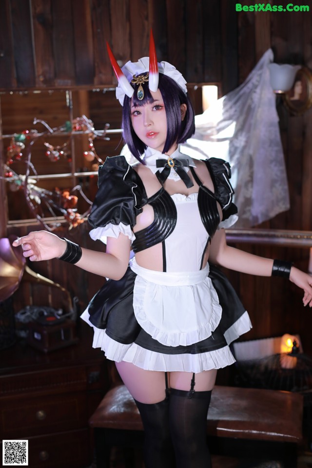 A woman dressed in a maid outfit posing for a picture.