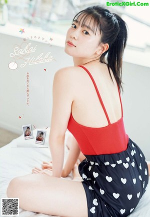 A woman sitting on a bed with her legs crossed.