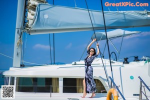 A woman standing on the deck of a sailboat.