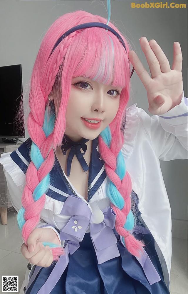 A woman with pink and blue hair wearing a sailor outfit.