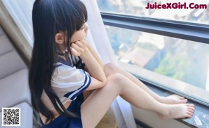 A woman in a sailor outfit sitting on a table.