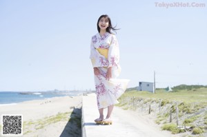 A woman in a black bathing suit standing on a road.