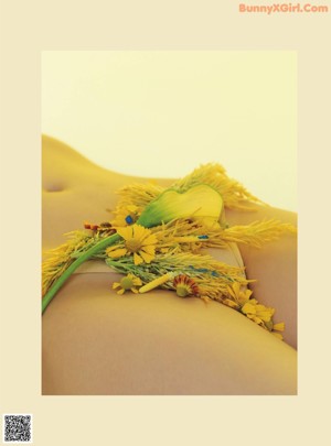 A woman in a blue bikini with yellow flowers on her back.