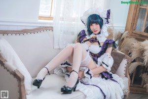 A woman dressed in a maid outfit posing for a picture.