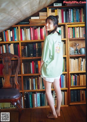 A woman sitting on a window sill with her legs crossed.