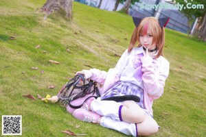 A woman in a purple and black outfit sitting on the ground.